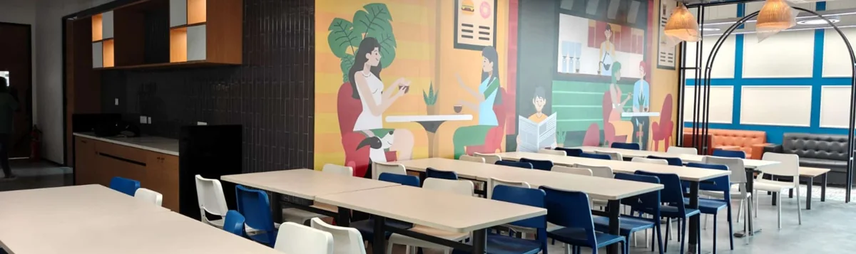 Shared dining area with colorful wall artwork, pendant lights and communal tables